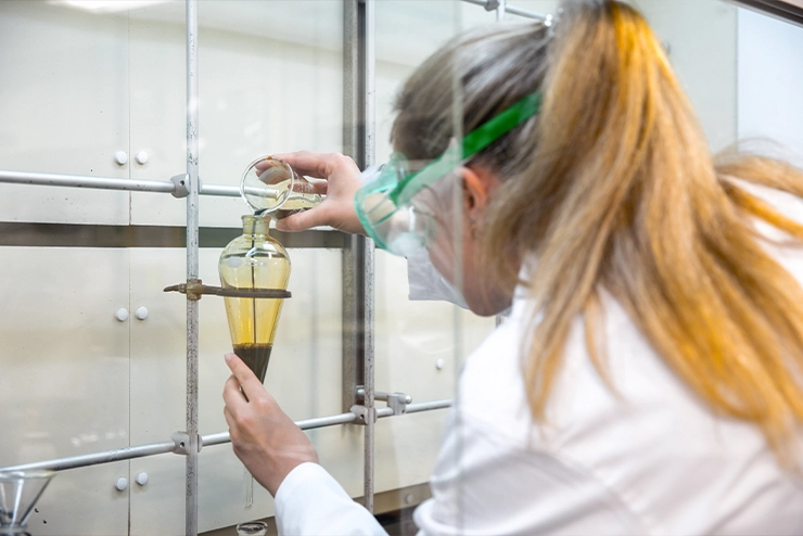 A girl at SEMO putting a specific liquid into a vile for experimentation at Southeast
