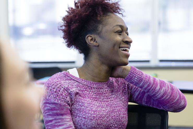 A young woman listens intently to a program hosted by a learning community.