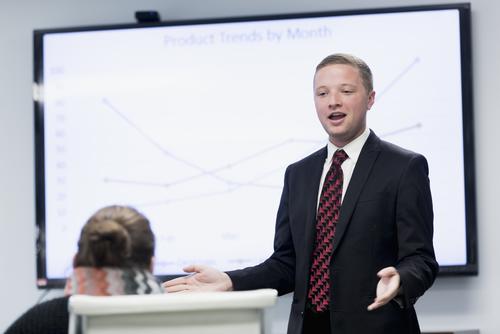 A business student gives a presentation to a client.