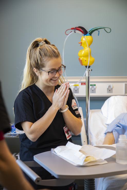 A nursing student smiles after a successful procedure in the Nursing Lab.