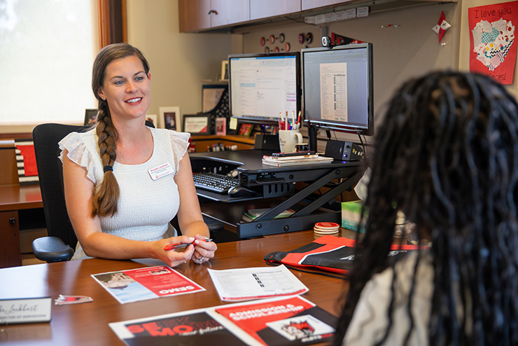 A SEMO faculty member talking with a student over scholarships.
