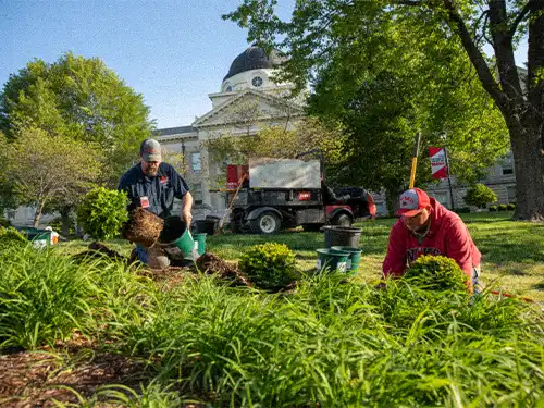 Facilities Management workers on the planter at Academic Hall 