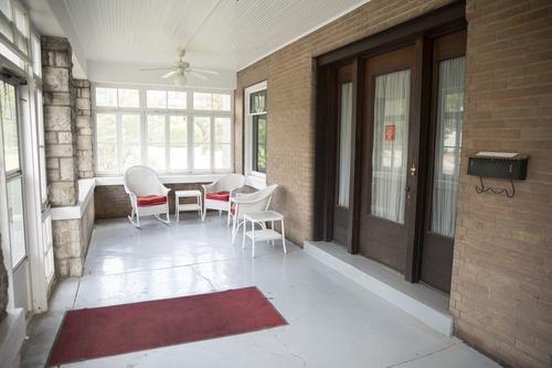 An enclosed porch with chairs and a table.