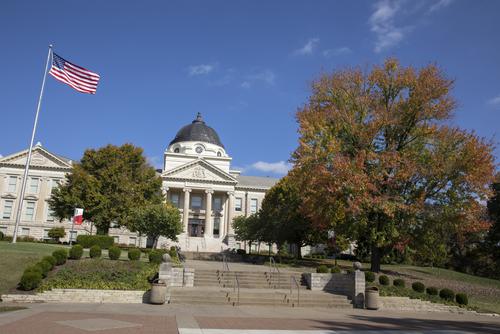 Academic Hall and changing fall leaves on a bright, sunny day.  