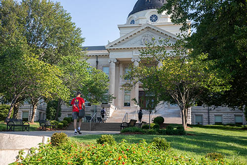 a student at SEMO heads up the walk toward the front of Academic Hall