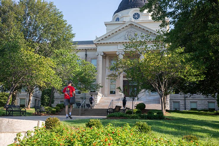 a student at SEMO heads up the walk toward the front of Academic Hall