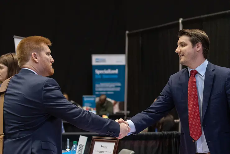 a semo student and an employer shake hands a the career services career expo