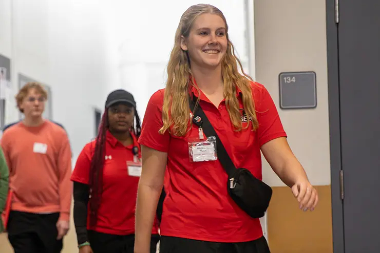 a young woman, head up and confident, leads a group down a hallway at the semo rec center