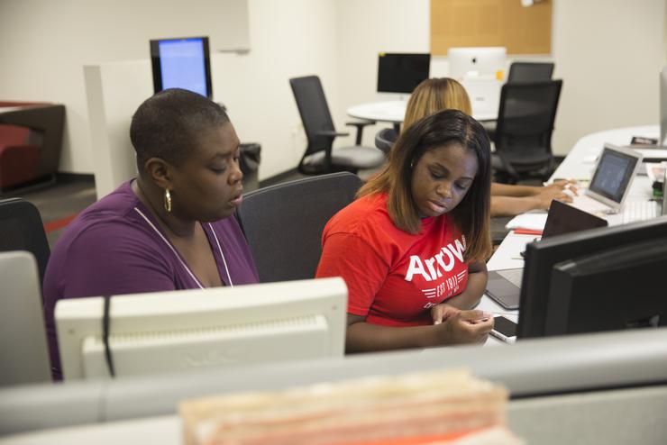 Dr. Tamara Zellars Buck, J.D., Faculty advisor to the Arrow, helps a student reporter.   