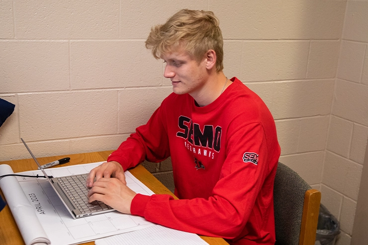 A student studying on his laptop while taking online classes at SEMO. 
