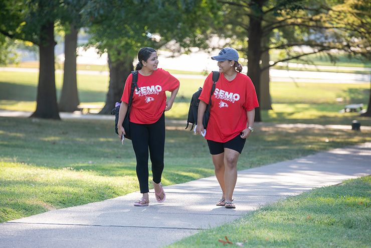 Students walk across campus in campus merch.