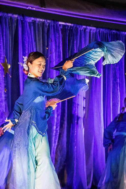 an international student at SEMO wearing her cultural dress performs a dnace on stage