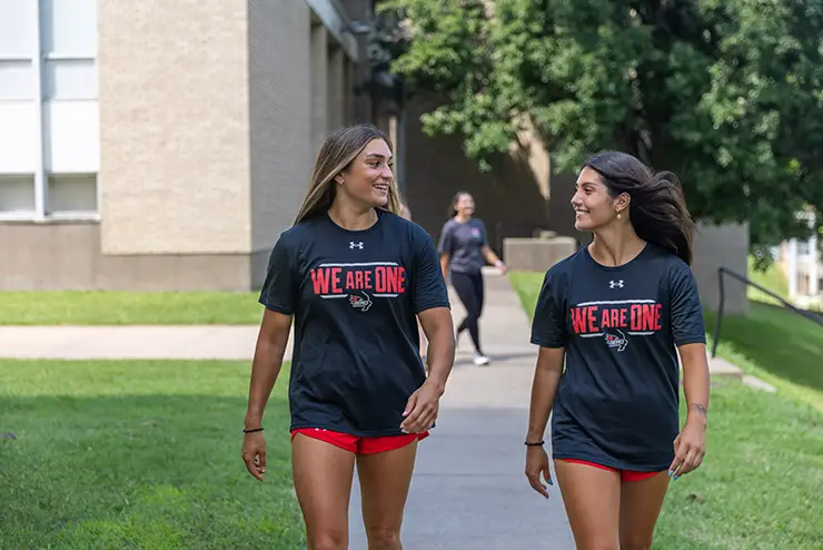 two students walk together across campus