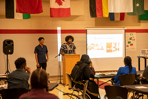 A pair of students give a presentation on henna cermonies.