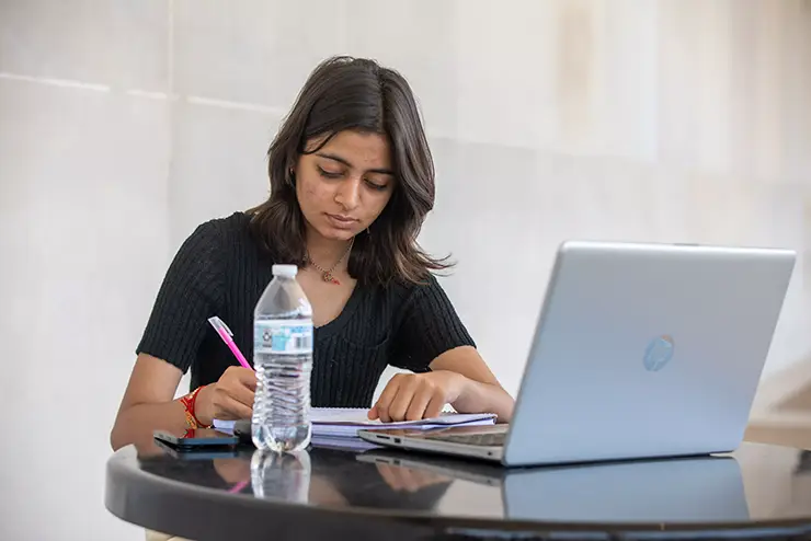 a student sits outside on the SEMO campus and studies