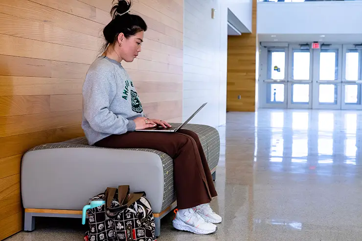 an international SEMO student sits in Magill Hall working on her laptop in between classes
