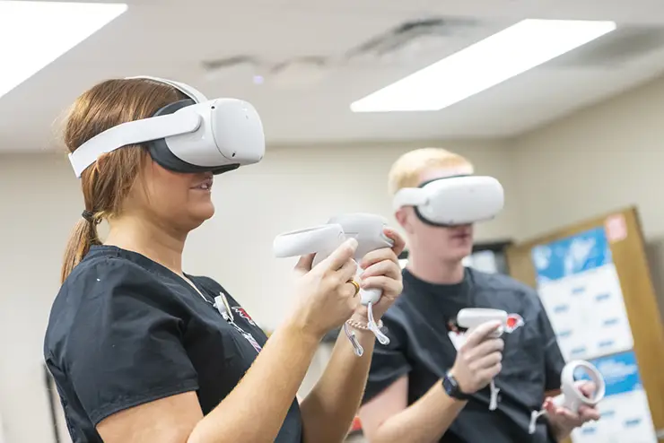 two semo nursing degree students using VR headsets and controls as part of one of their classes