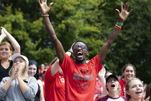 Southeast Missouri State University student cheering enthusiastically in the crowd with arms raised at a campus event.