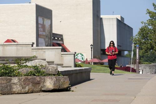 A Southeast Missouri State University student walks along the sidewalk in front of the University Center on campus.