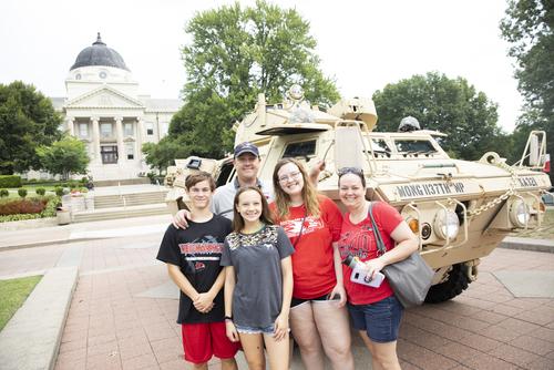 Family standing in front of Academic Hall at Southeast Missouri State University campus for family weekend events.