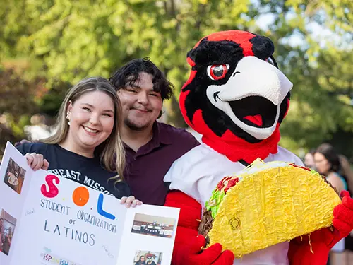 SEMO students participating in the involvement fair pose with Rowdy who is holding a taco
