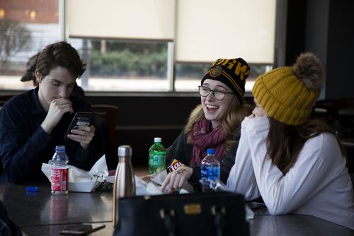 A student laughs while eating with peers at St. Vincent’s Commons at the River Campus.