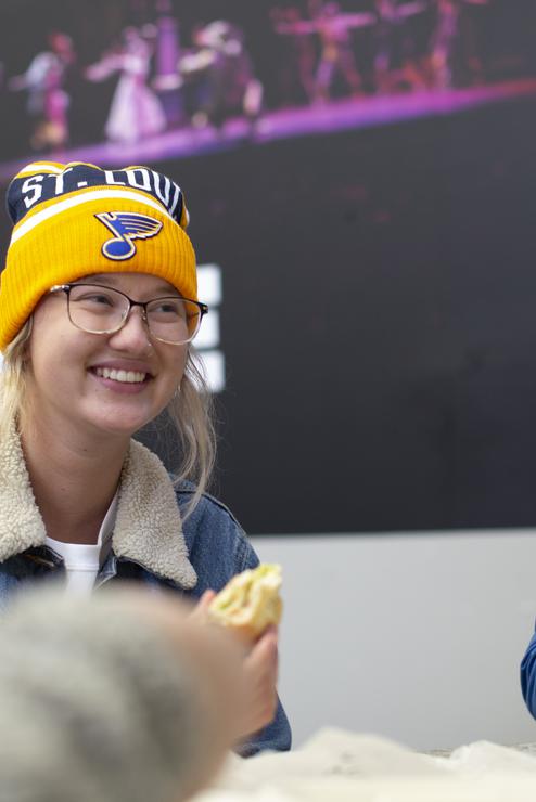 A student smiles while dining with peers at the University Center. 
