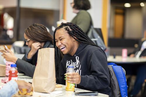 A student laughs during lunch with peers at the University Center. 