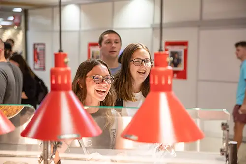 students wait at a counter in copper dome cafe for their food order