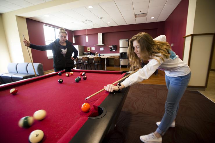two semo students who are on campus residentsplay a game of pool in the floor lounge at Laferla Hall. 