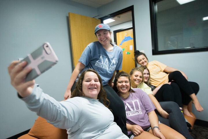 Floormates crowd on a couch in their floor lounge to take a group photo in Towers North. 