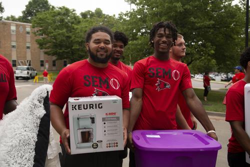 SEMO football players help new students carry belongings to their rooms on move-in day.