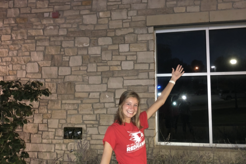 Accounting student, Hannah Kroencke, wears a Redhawk shirt and stands in front of LaFerla Hall.