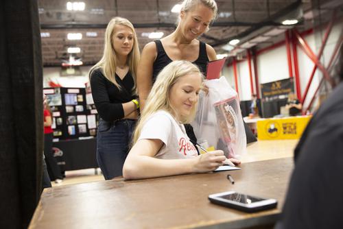 A student, with her family, signs a form at check-in on Move-In Day at SEMO. 