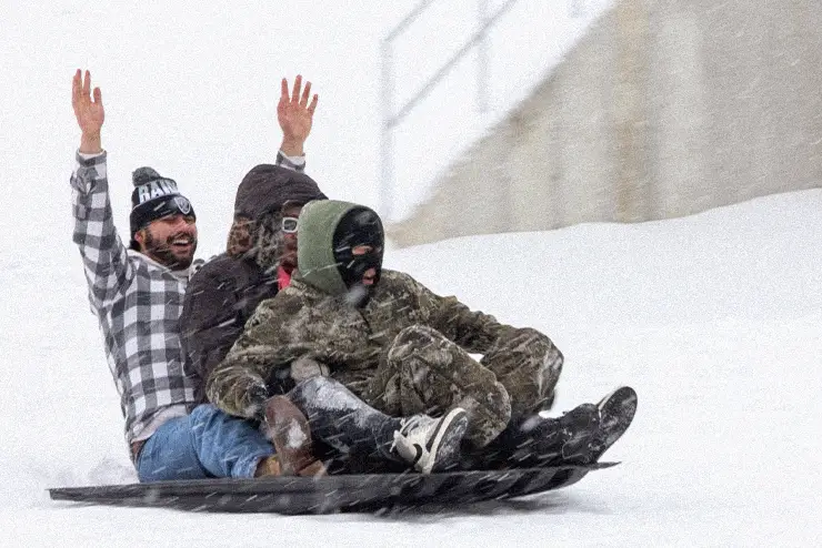 Students sledding on a snowy day at SEMO