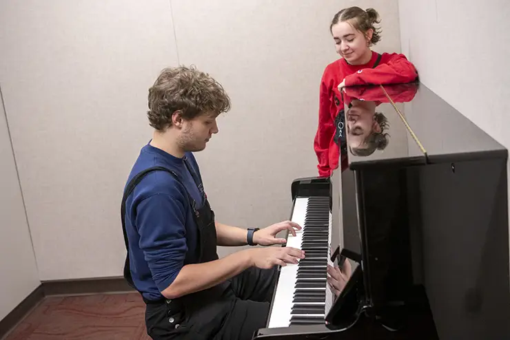 two SEMO students who are members of the arts and media housing community practice the piano in their dorm