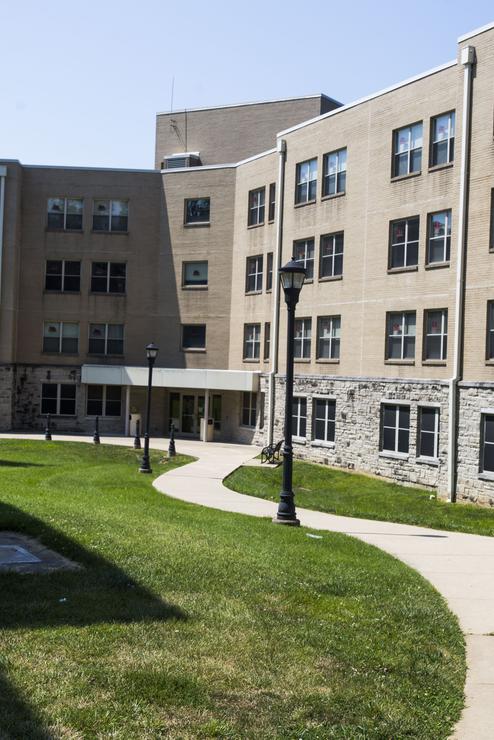A view of the east facing entrance of Vandiver Hall on a bright day where the sun reflects off the windows. 