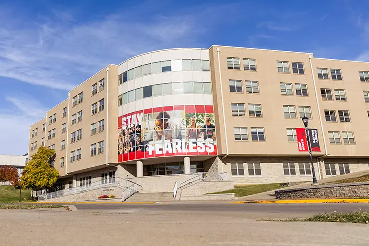 a view of the front facade of Vandiver Hall facing the street with branding signage in the windows