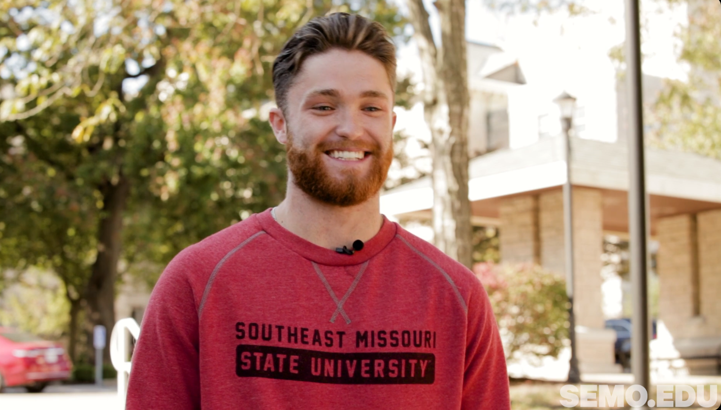 Daniel Frew smiles toward the camera during an interview.