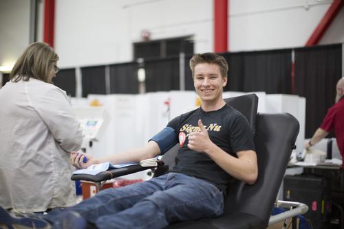 A student gives a thumbs up at a Greek blood drive. 