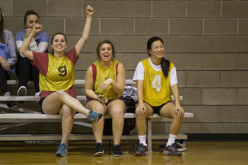 Students cheer from the bench during an intramural basketball game.