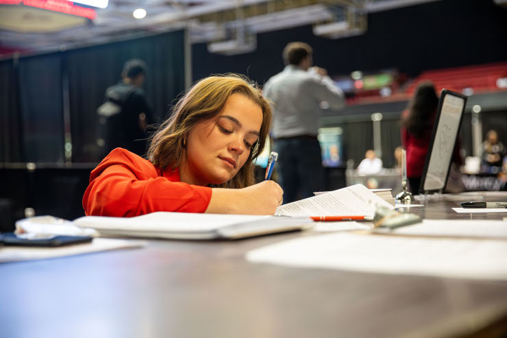 A student signs a form during the career fair.