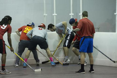 Students play floor hockey in Parker Gym as part of intramural sports. 