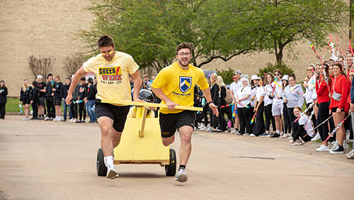 Students pull a peer in a decorated wagon during the Greek Games.