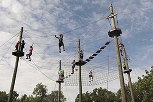 A group of Camp Redhawk students work together to complete the Challenge Course.