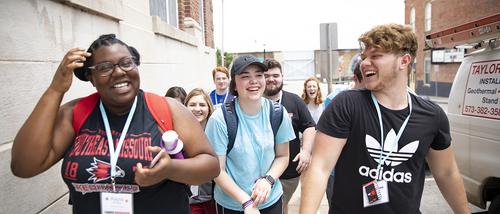 A diverse group of students attending CampRedhawk walk along the street in downtown Cape Girardeau.