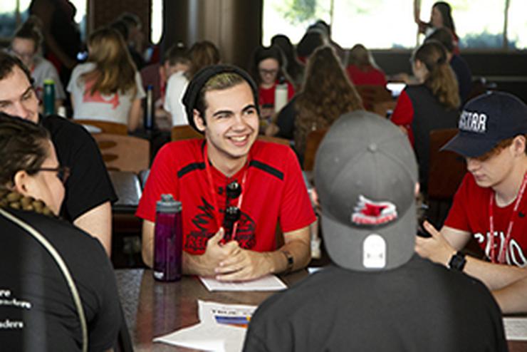 A group of students sit around a table talking to each other about the true colors of personalities.  