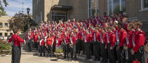 Southeast Marching Band directed by a Drum Major on the stairs outside the Wehking Alumni Center.