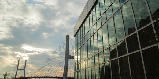 the glass front of the River Campus Cultural Arts Center with the Mississippi bridge in the background