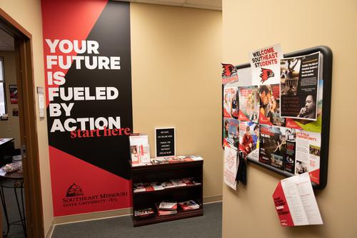 Display of different marketing pieces and a wall graphic that states Your future is fueled by action start here